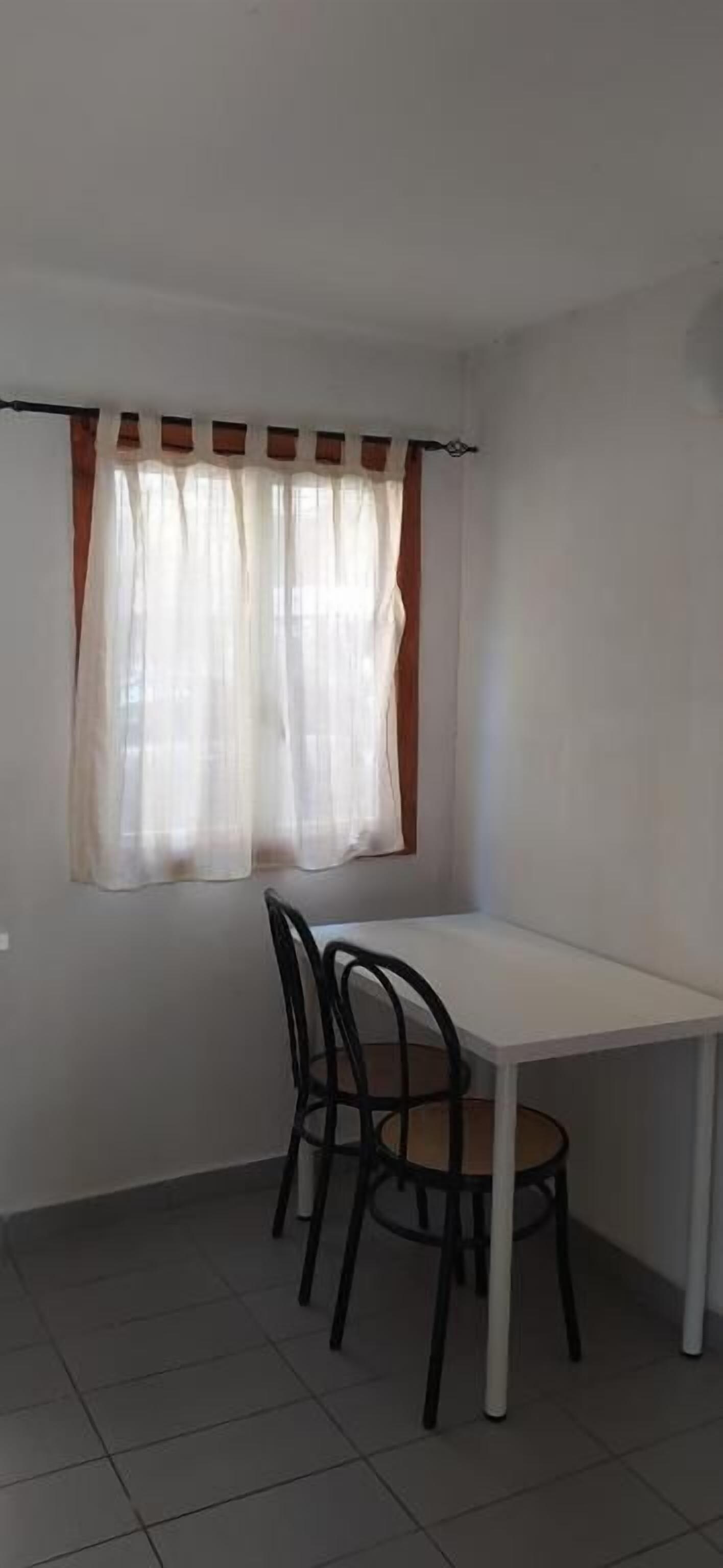 A small dining area with a white table and four chairs.