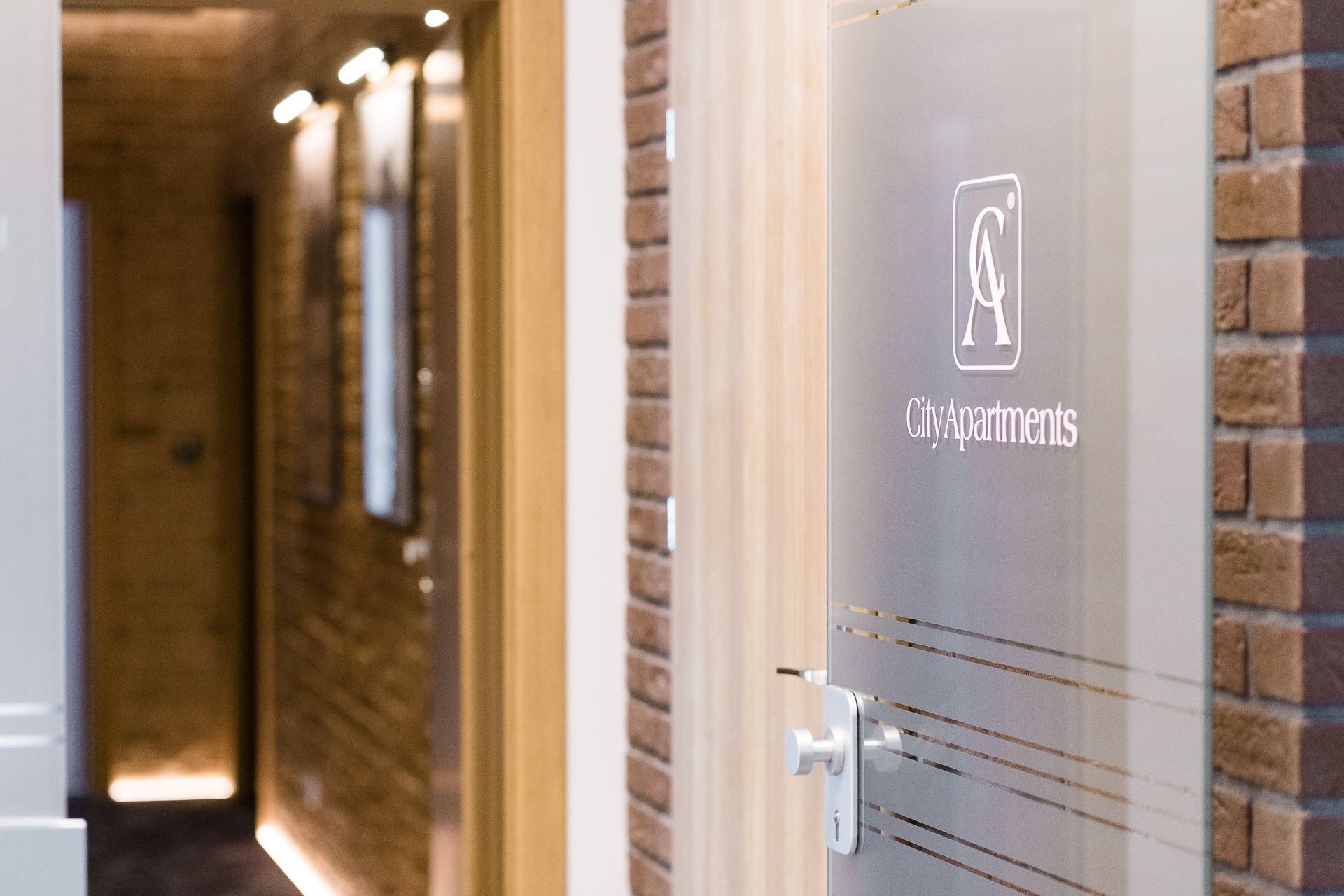 Un pasillo con una puerta que dice "CityApartments" y una mirilla.