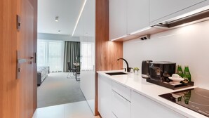 Een moderne keuken met een ingebouwde oven, een koffiezetapparaat en een spoelbak.