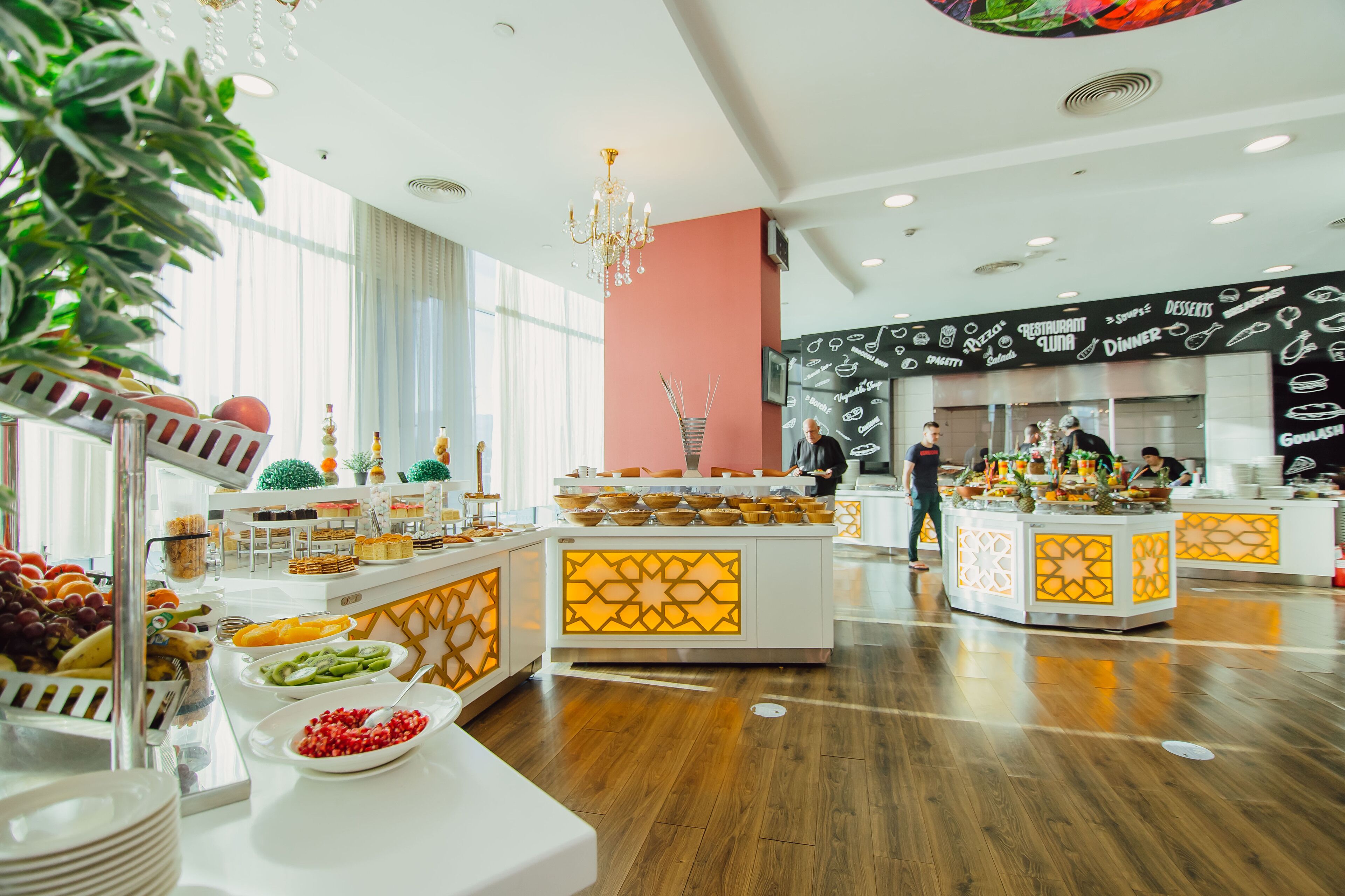 A buffet area with various food stations and a kitchen in the background.