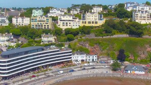 A coastal town with a mix of modern and traditional buildings, a waterfront promenade, and a large public square. - Astor House (Torquay)