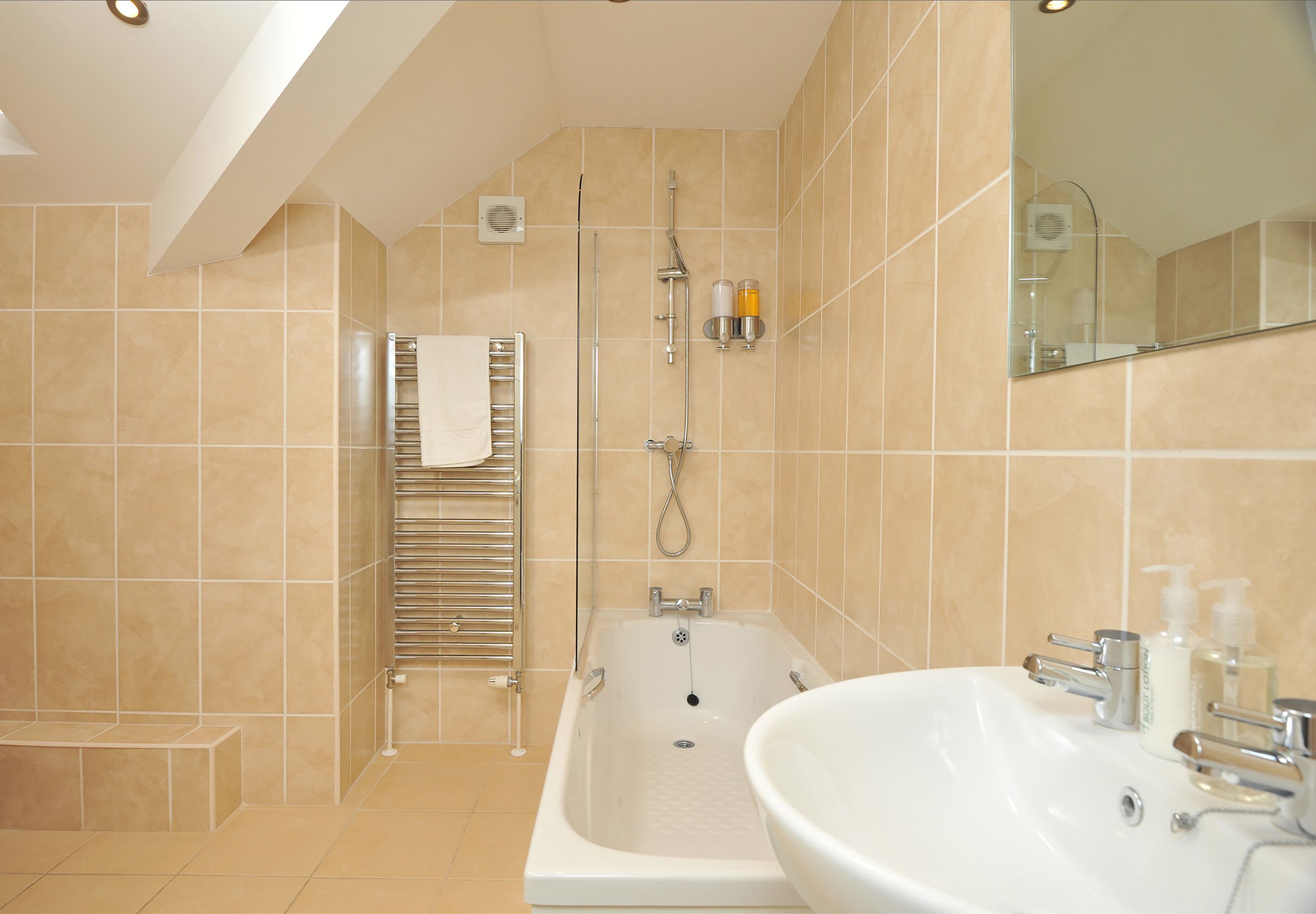 A modern bathroom with a bathtub, a sink, and a shower.