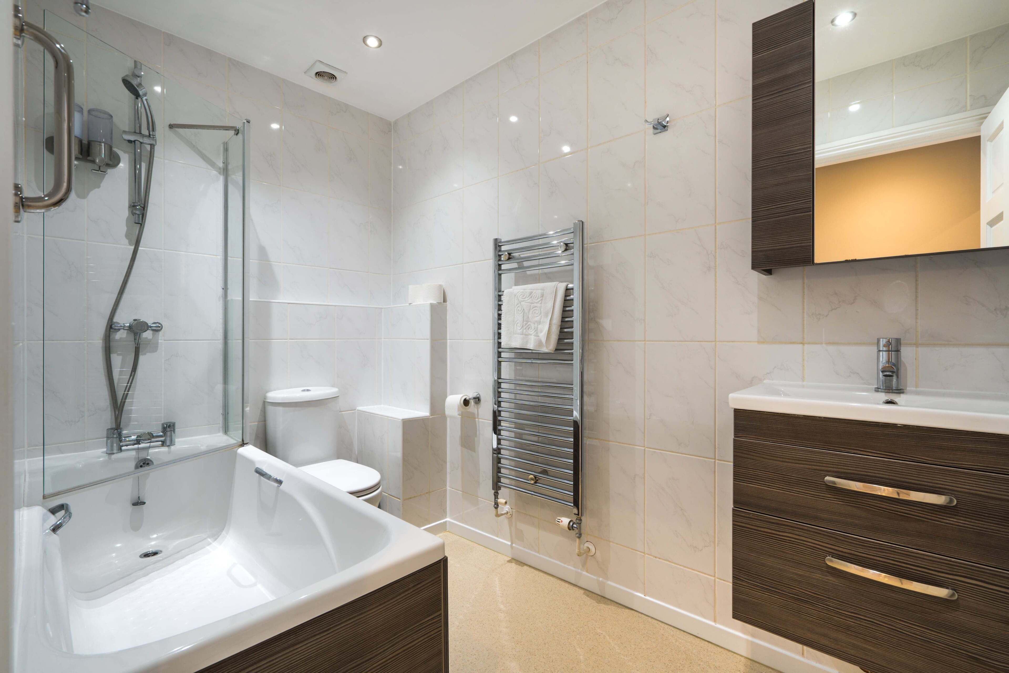 Un baño moderno con bañera, inodoro y tocador.