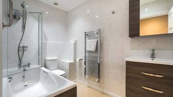 Un baño moderno con bañera, inodoro y tocador.