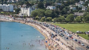 A coastal town with a beach, promenade, and residential buildings in the background. - Astor House (Torquay)