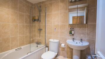 Un baño moderno con bañera, inodoro y lavamanos.
