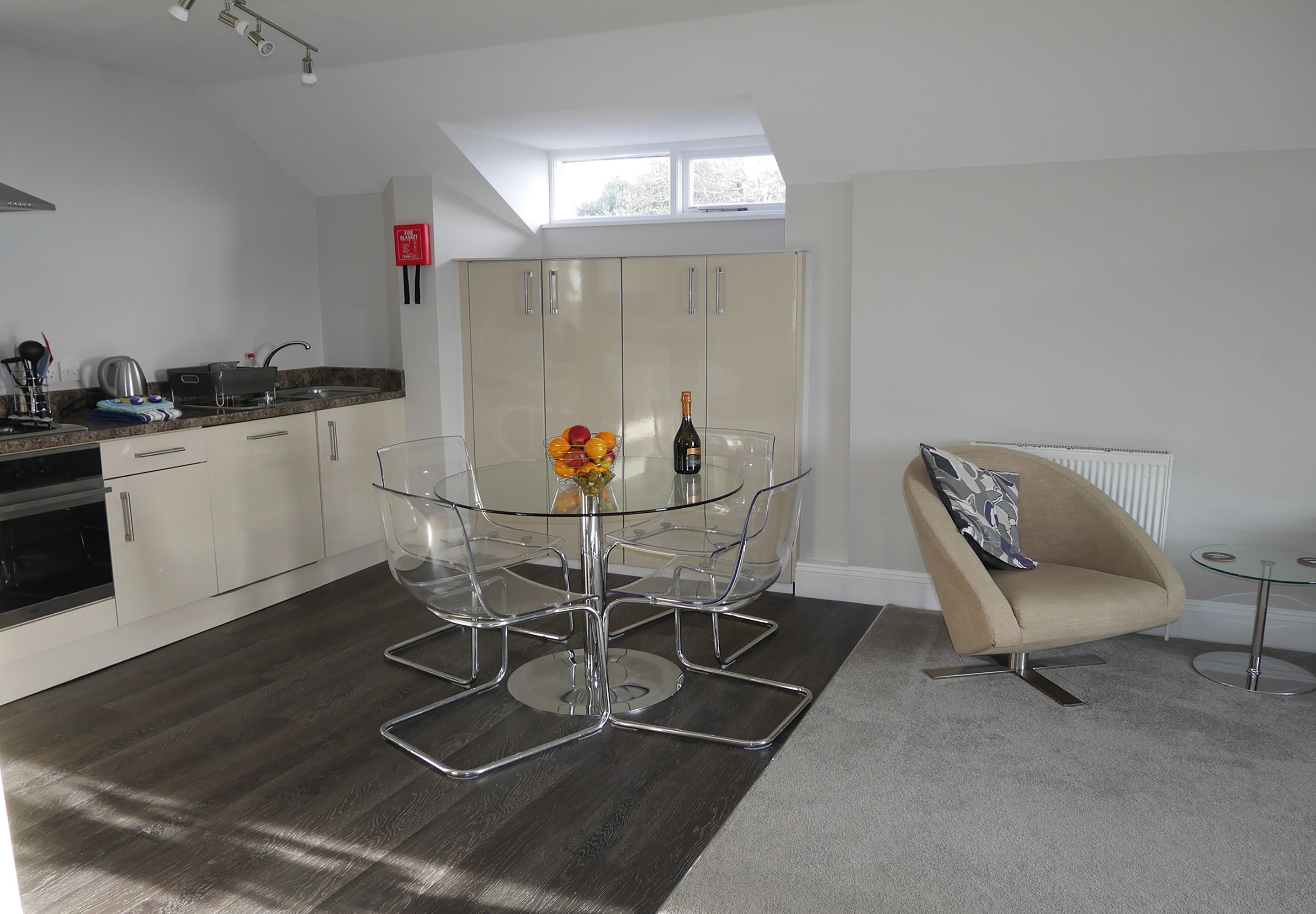 A modern kitchen with a dining area, a sofa, and a small table.