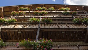Un bâtiment en bois doté de nombreux balcons, chacun étant agrémenté de jardinières fleuries.