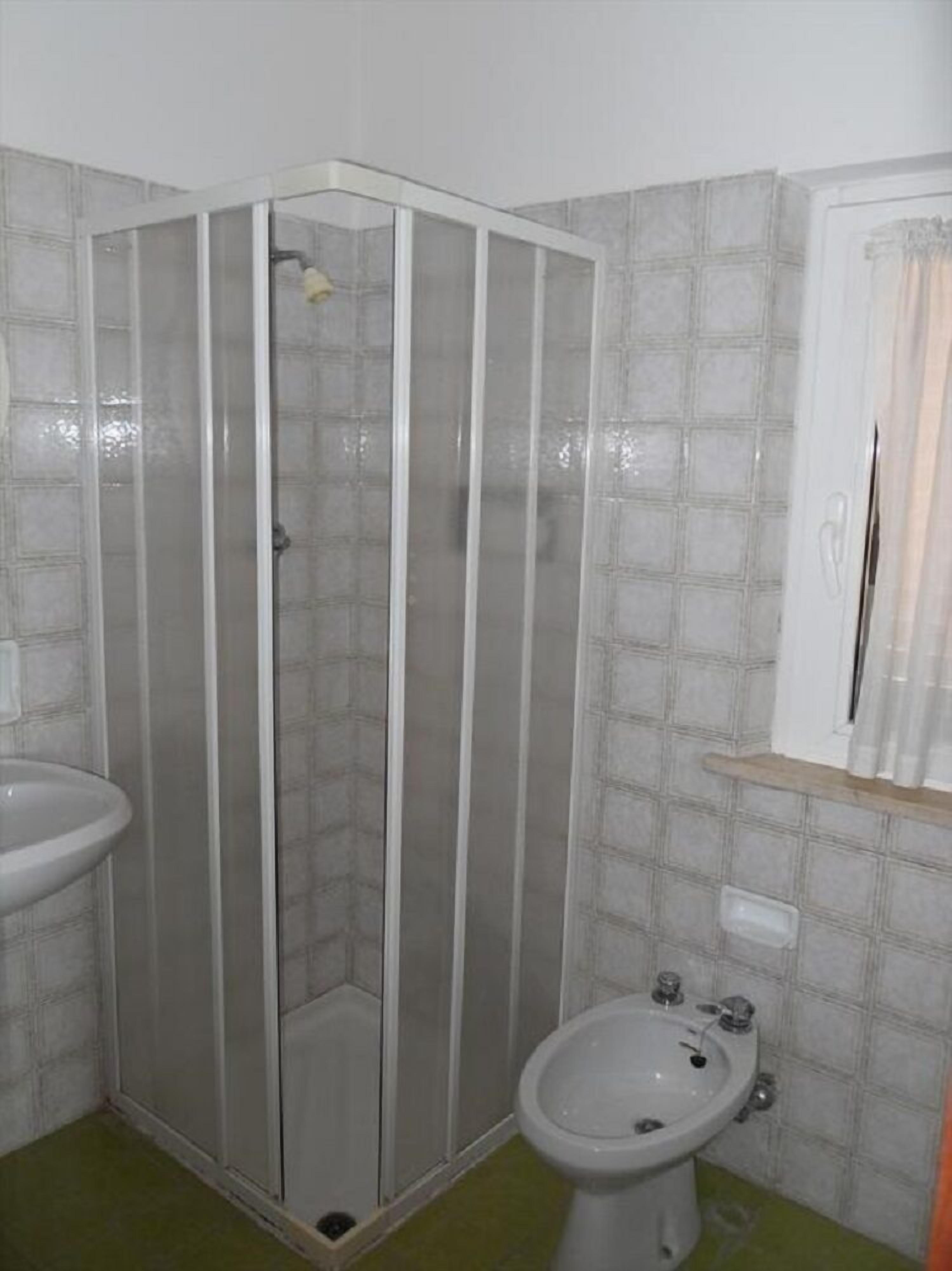 Ein Badezimmer mit Duschkabine, Waschbecken und Bidet.