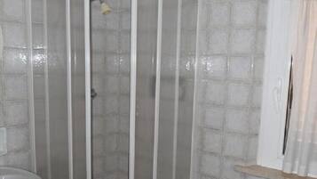 Ein Badezimmer mit Duschkabine, Waschbecken und Bidet.