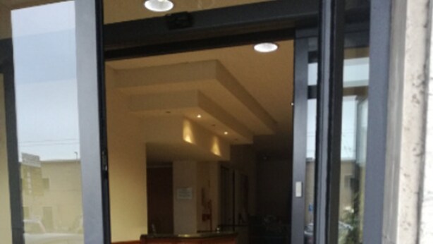 Una entrada de hotel con recepción, zona de espera y suelo estampado.