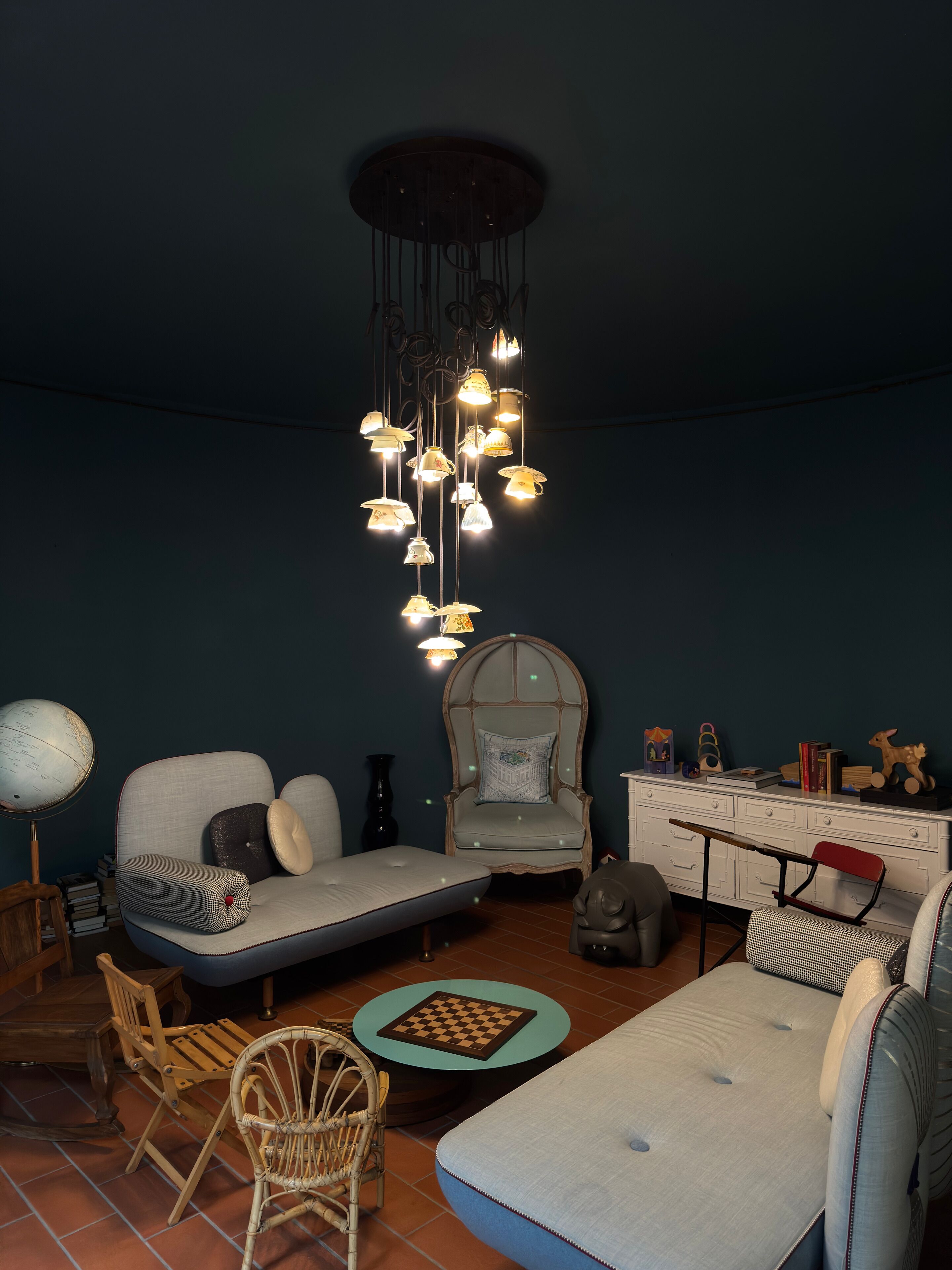 A cozy living room with a sofa, armchair, and a small table with a chessboard.