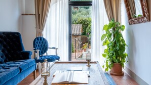 A living room with a blue sofa, a coffee table, and a potted plant. - Terre di Baccio (Greve in Chianti)