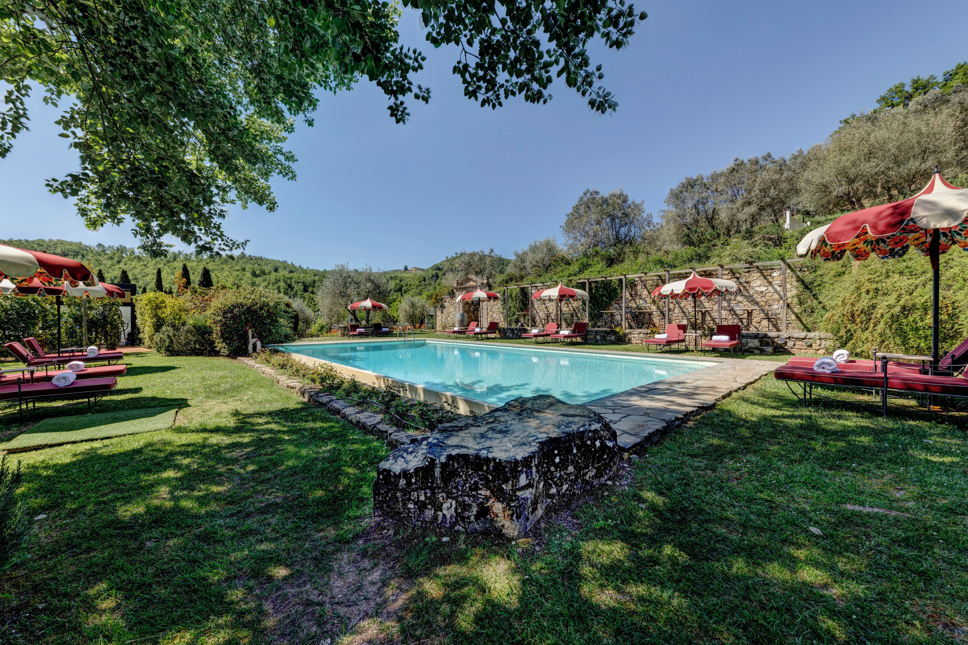Una piscina al aire libre de temporada, sombrillas