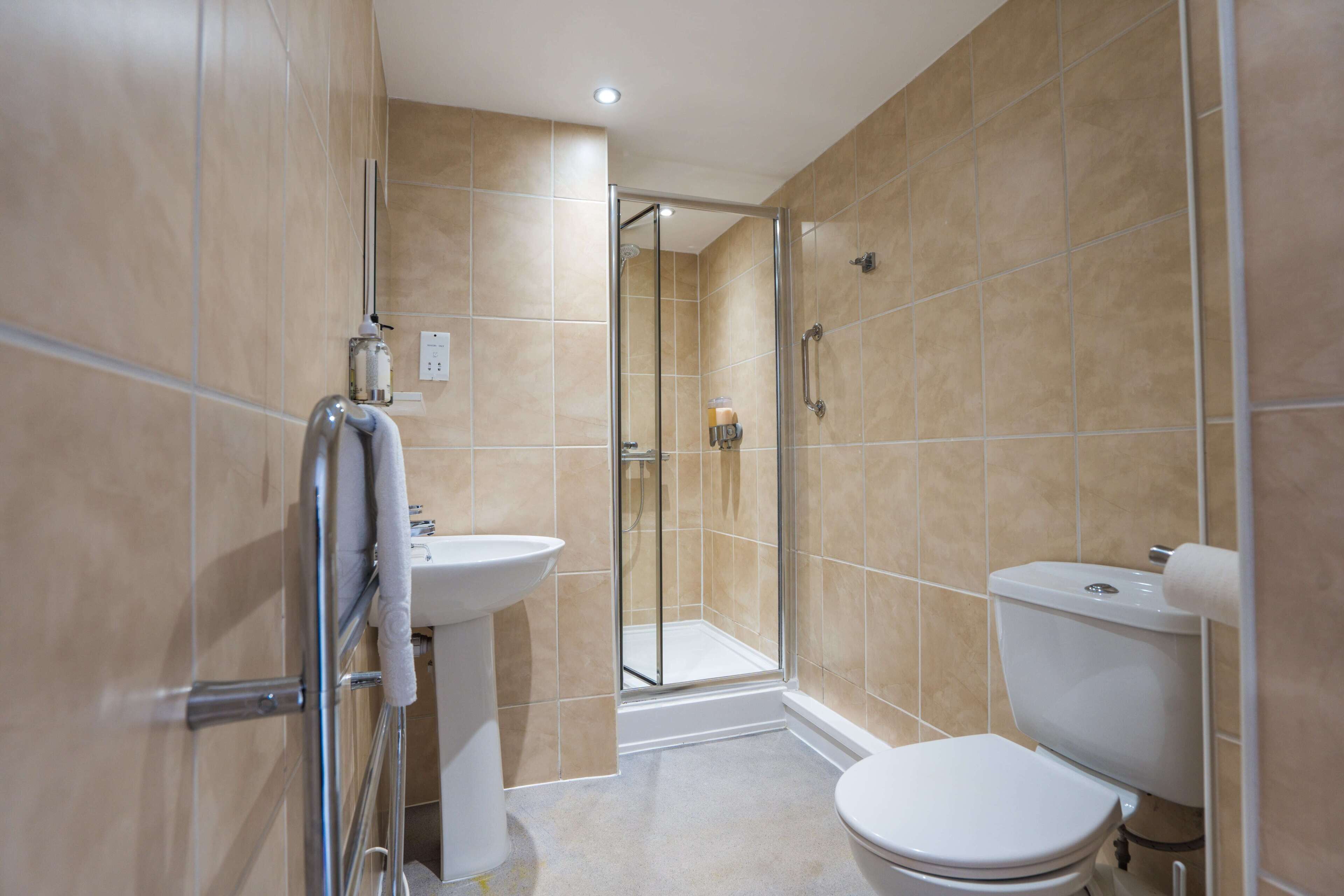 A bathroom with a shower, toilet, and sink.