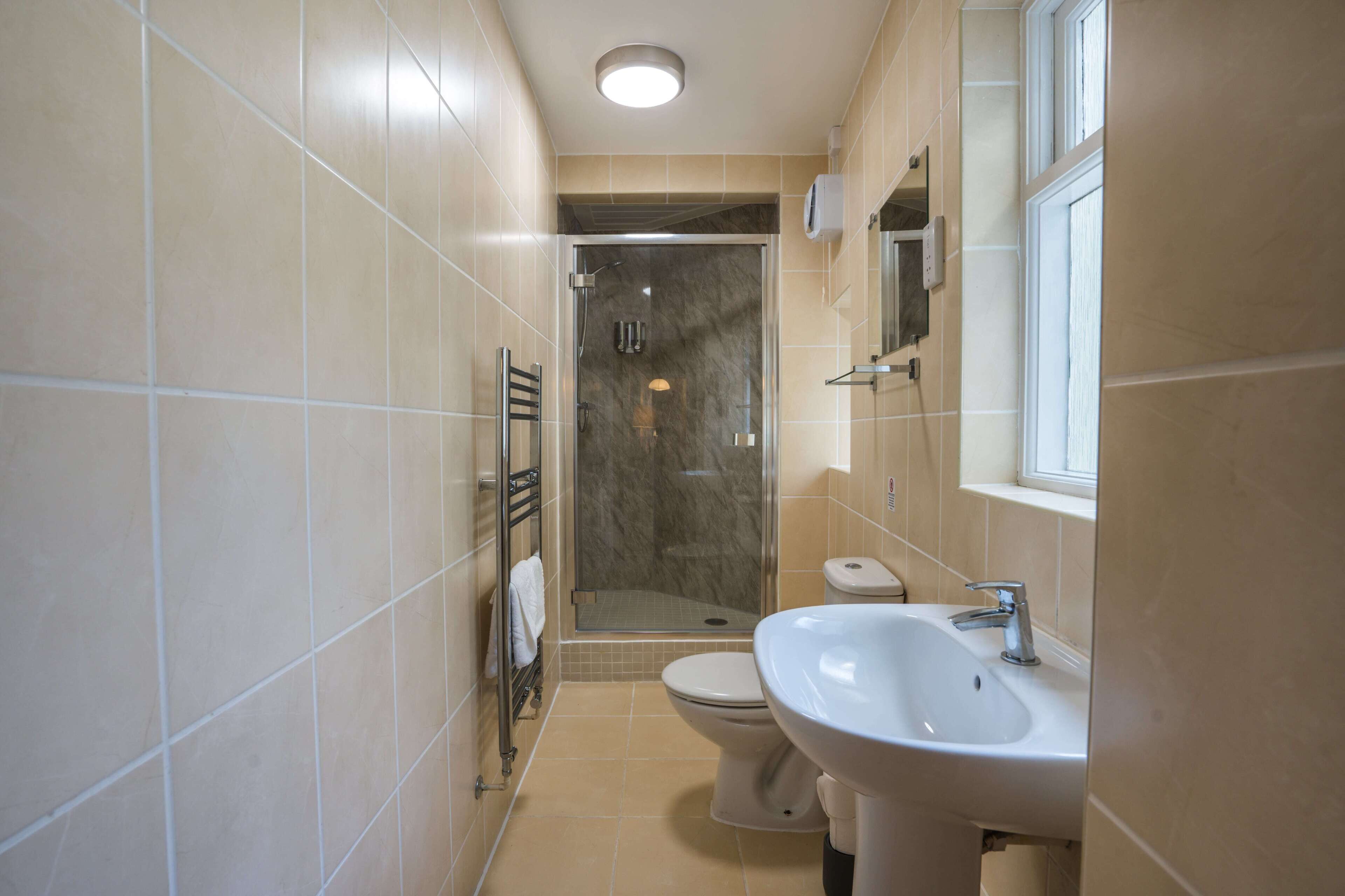 Un baño con ducha, inodoro y lavamanos.