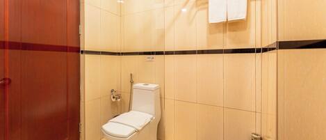 A bathroom with a toilet, a towel rack, and a door.