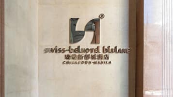 A marble wall with a logo and text for the Swiss-belt Hotel Blulan.