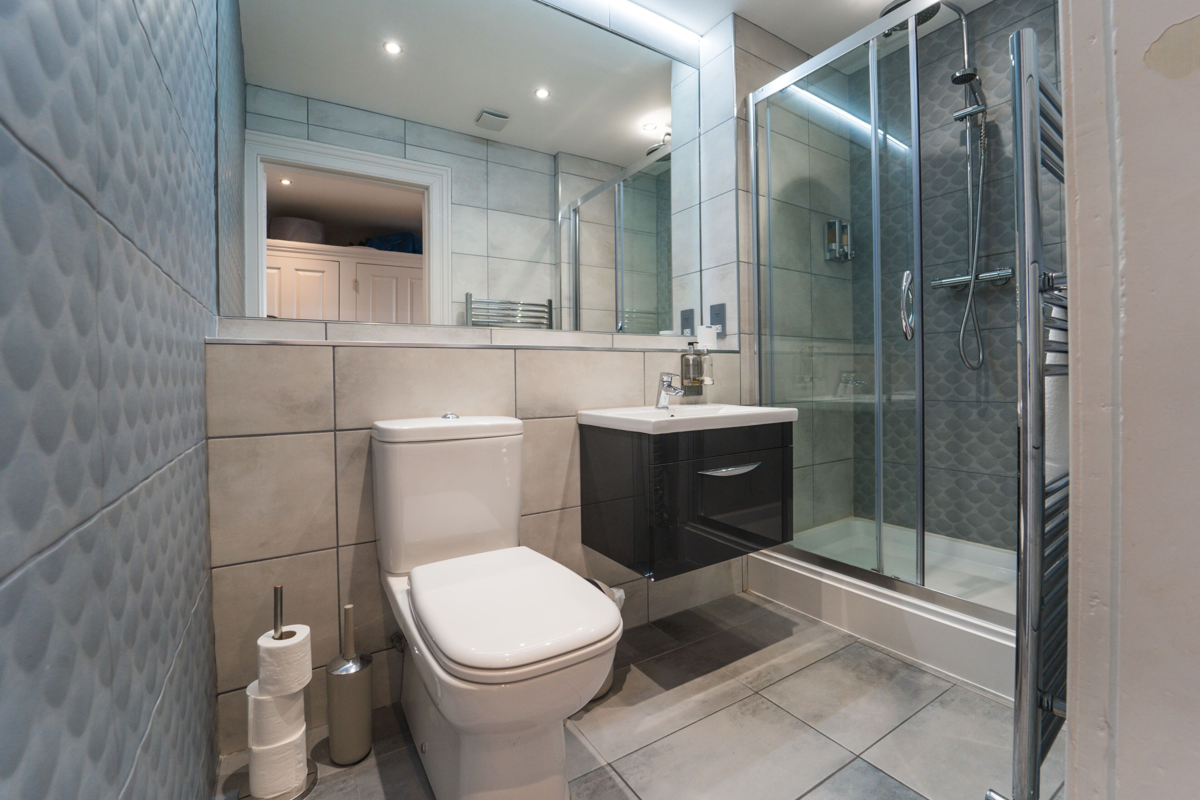 Ein modernes Badezimmer mit Toilette, Waschbecken und einer Duschkabine.