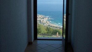 Un pasillo estrecho con vistas al océano y a un pueblo costero.