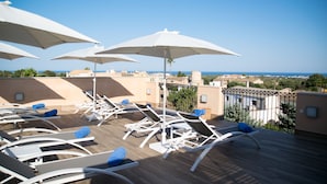 A rooftop terrace with white lounge chairs and umbrellas, overlooking a coastal landscape. - Petit Hotel Sant Miquel - Adults Only (Santanyi)
