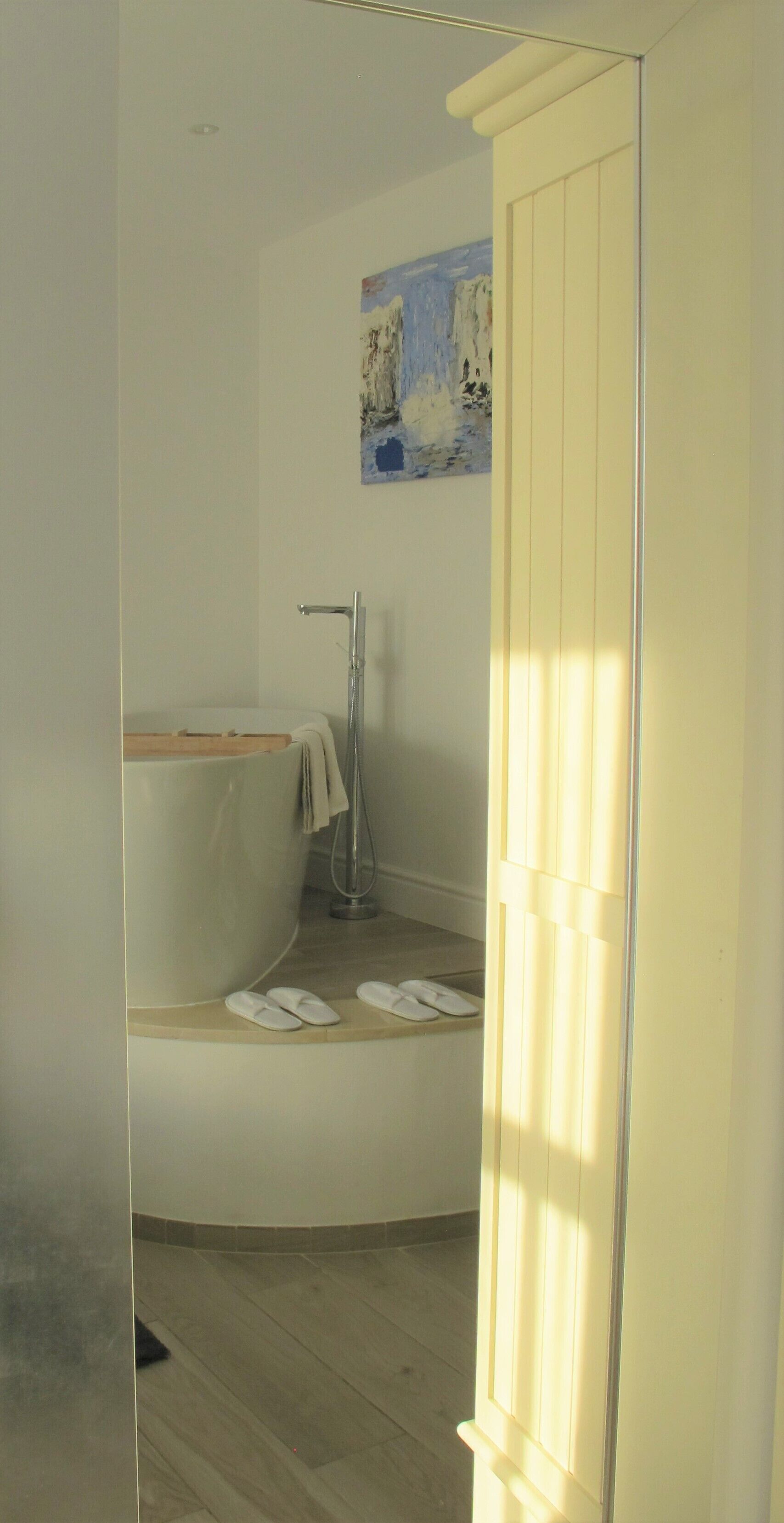 A bathroom with a bathtub, a shower, and a towel rack.