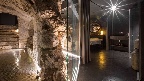 A modern interior with stone walls, a glass partition, and a starry light effect.