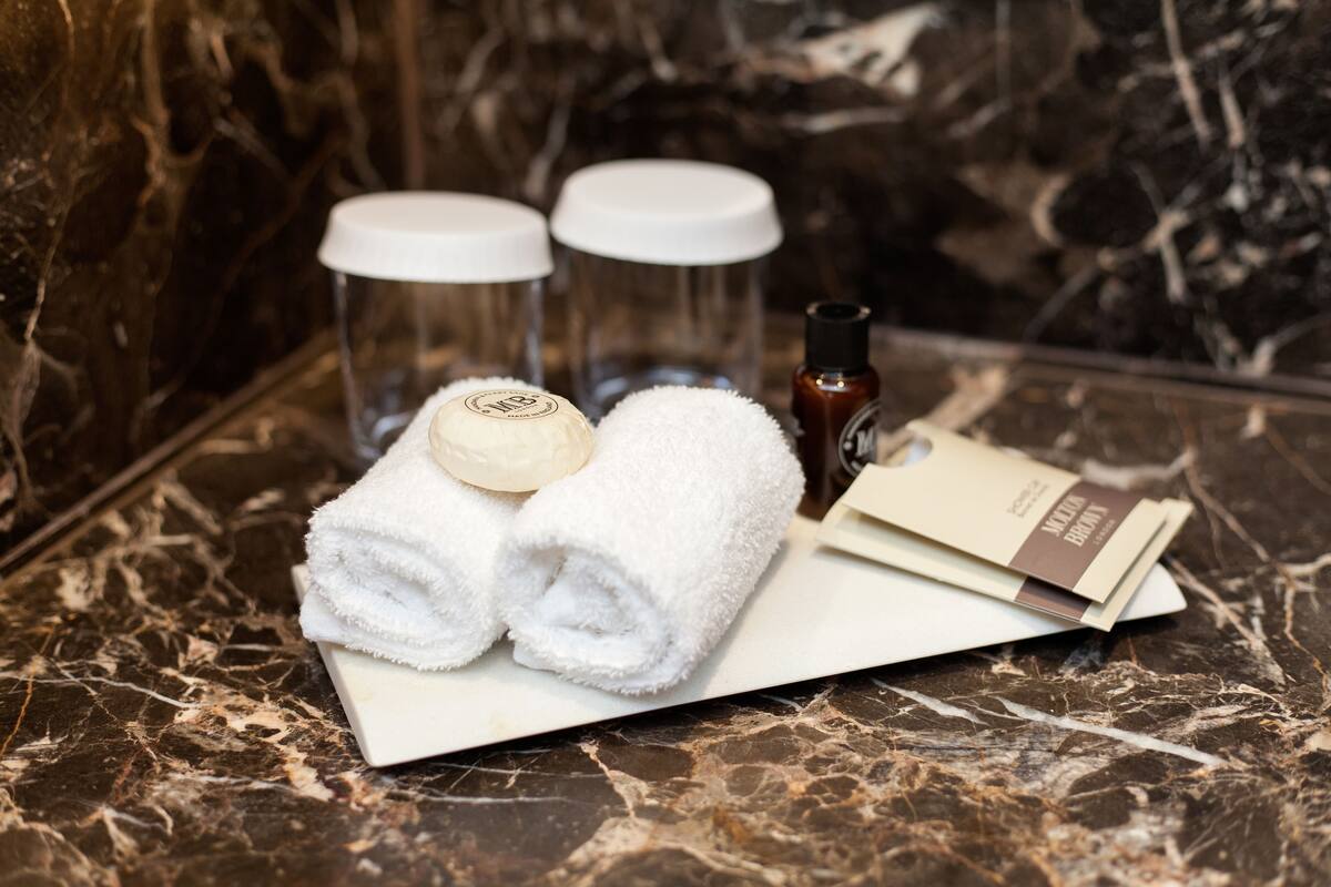 designer toiletries, hair dryer, slippers, towels