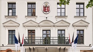 A historic building with the name "PACAI" and a coat of arms above the entrance.