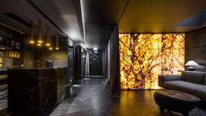 A modern interior with a reception desk, a sofa, and a wall with a textured pattern.