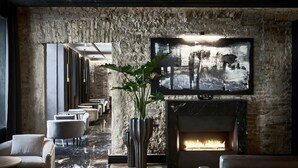 A modern lounge with a fireplace, seating, and a large painting on the wall. - Hotel Pacai, a Member of Design Hotels (Vilnius)