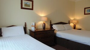 A hotel room with two single beds, a wooden dresser, and two bedside lamps. - Harrowgate Hill Lodge (Darlington)