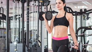 Un gimnasio con equipo de ejercicio, incluyendo pesas y máquinas de pesas.