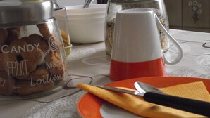 A table with a plate, a knife, a spoon, and a glass jar labeled "CANDY FRUIT Lollies".
