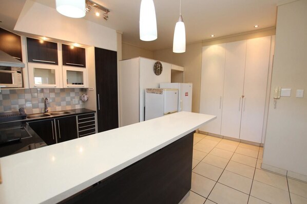 Departamento | Cocina privada | Refrigerador con congelador, microondas, horno y parrilla de estufa