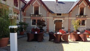 A courtyard with wicker furniture and potted plants. - Château de Belle Poule  (Les Ponts-de-Ce)