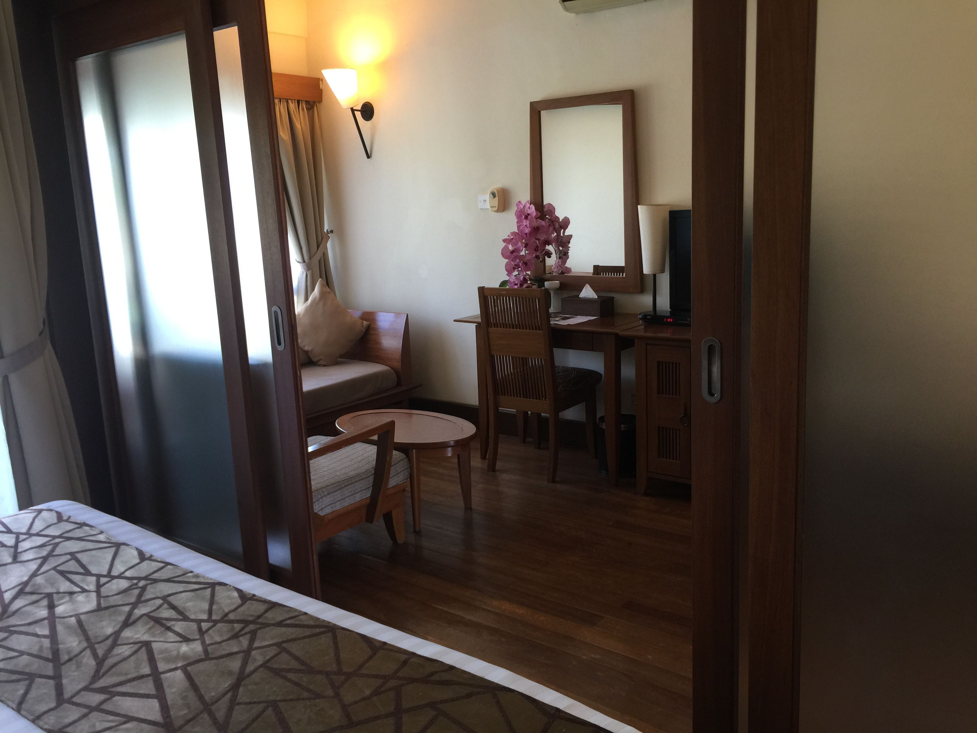 A hotel room with a bed, a sofa, a desk, and a chair.