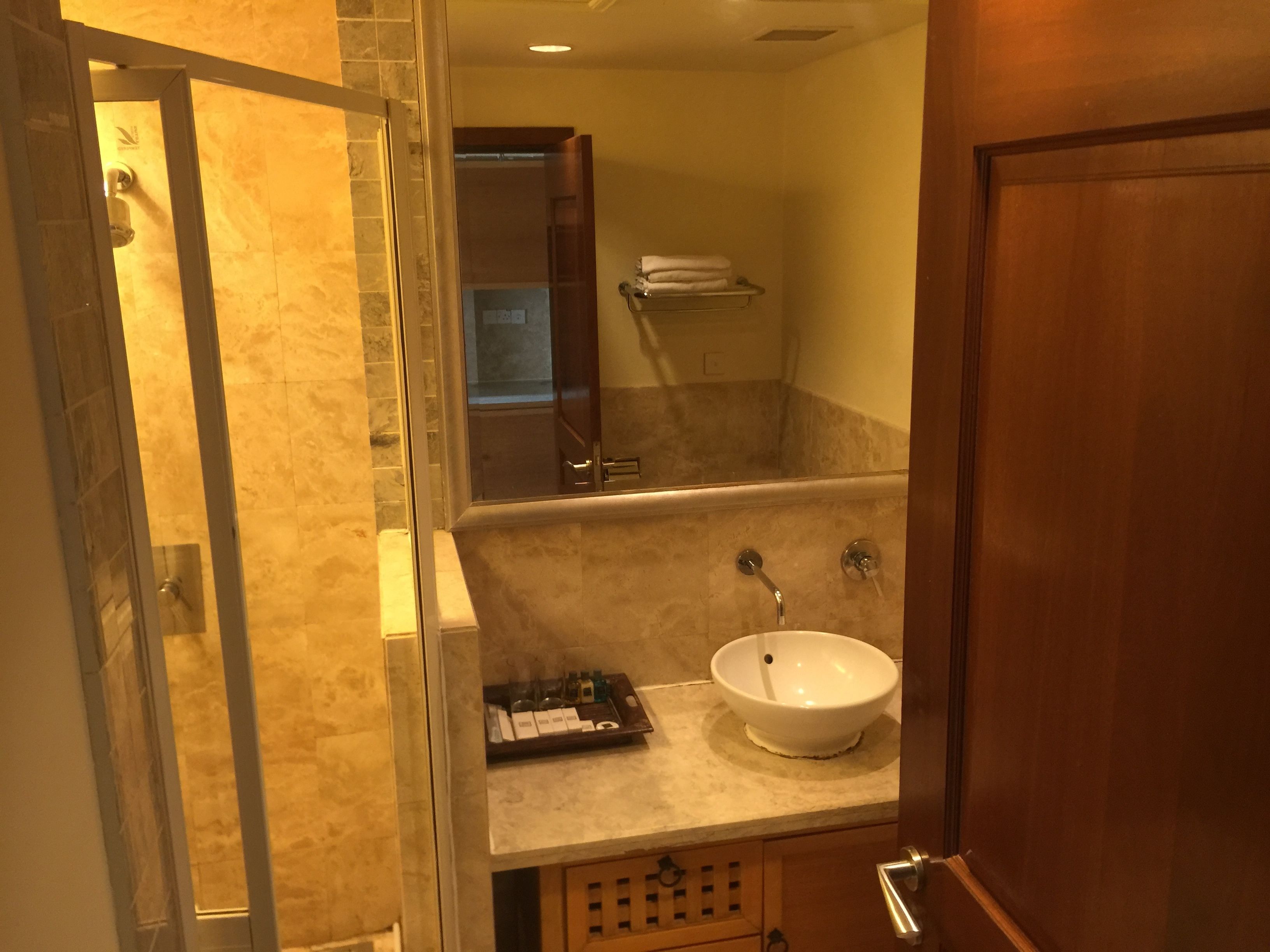 A bathroom with a glass shower enclosure, a sink with a basin, and a towel rack.