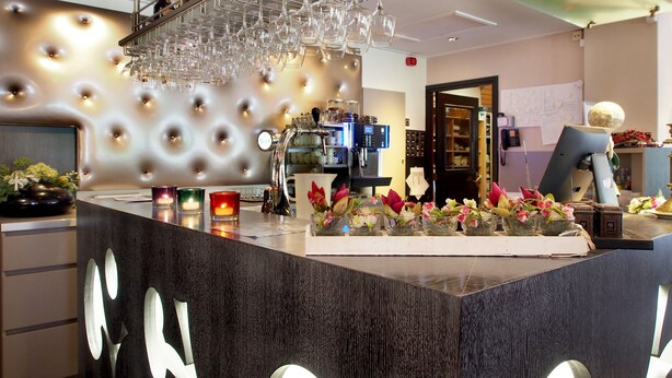 A modern bar area with a tufted wall, a wine rack, and a coffee machine. - Villavelo Twente (Ootmarsum)
