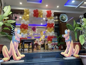 A hotel entrance decorated with balloons and cartoon character cutouts.
