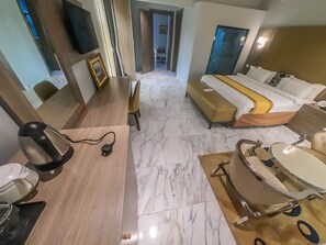 Una habitación de hotel con cama, mesita de noche y baño con lavabo y espejo.