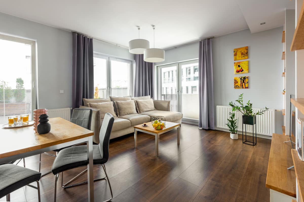 Een moderne woonkamer met een bank, salontafel en een eethoek.
