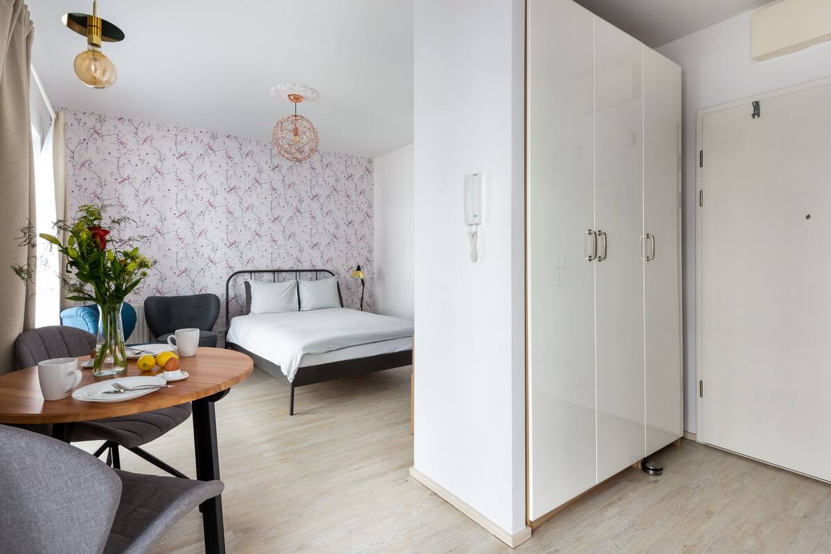 Een slaapkamer met een bed, nachtkastje en een kledingkast.