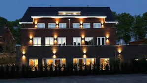 A two-story building with multiple windows and a flat roof. - Heuvelrijk Berg en Dal (Groesbeek)