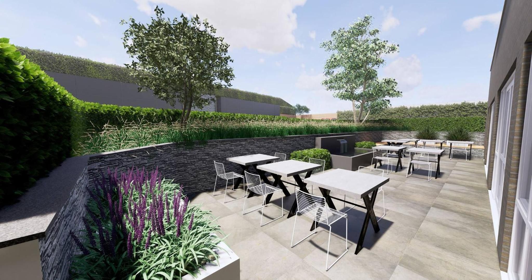 Un espace extérieur aménagé en terrasse, avec un sol en pierre, plusieurs tables et chaises, et une variété de plantes.