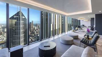 Quarto de hotel moderno com vista panorâmica da cidade, amplo espaço de estar e design minimalista.