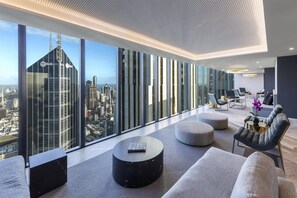 Quarto de hotel moderno com vista panorâmica da cidade, amplo espaço de estar e design minimalista.