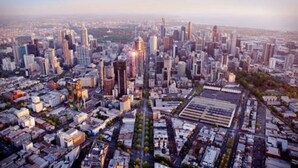 A cityscape with a dense cluster of high-rise buildings, a central skyscraper, and a grid of streets.