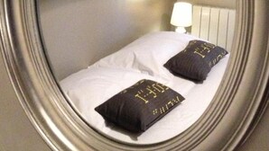 A bedroom with a bed, pillows, a nightstand, and a wall-mounted picture. - Demeure et Dependance (Tassin-la-Demi-Lune)