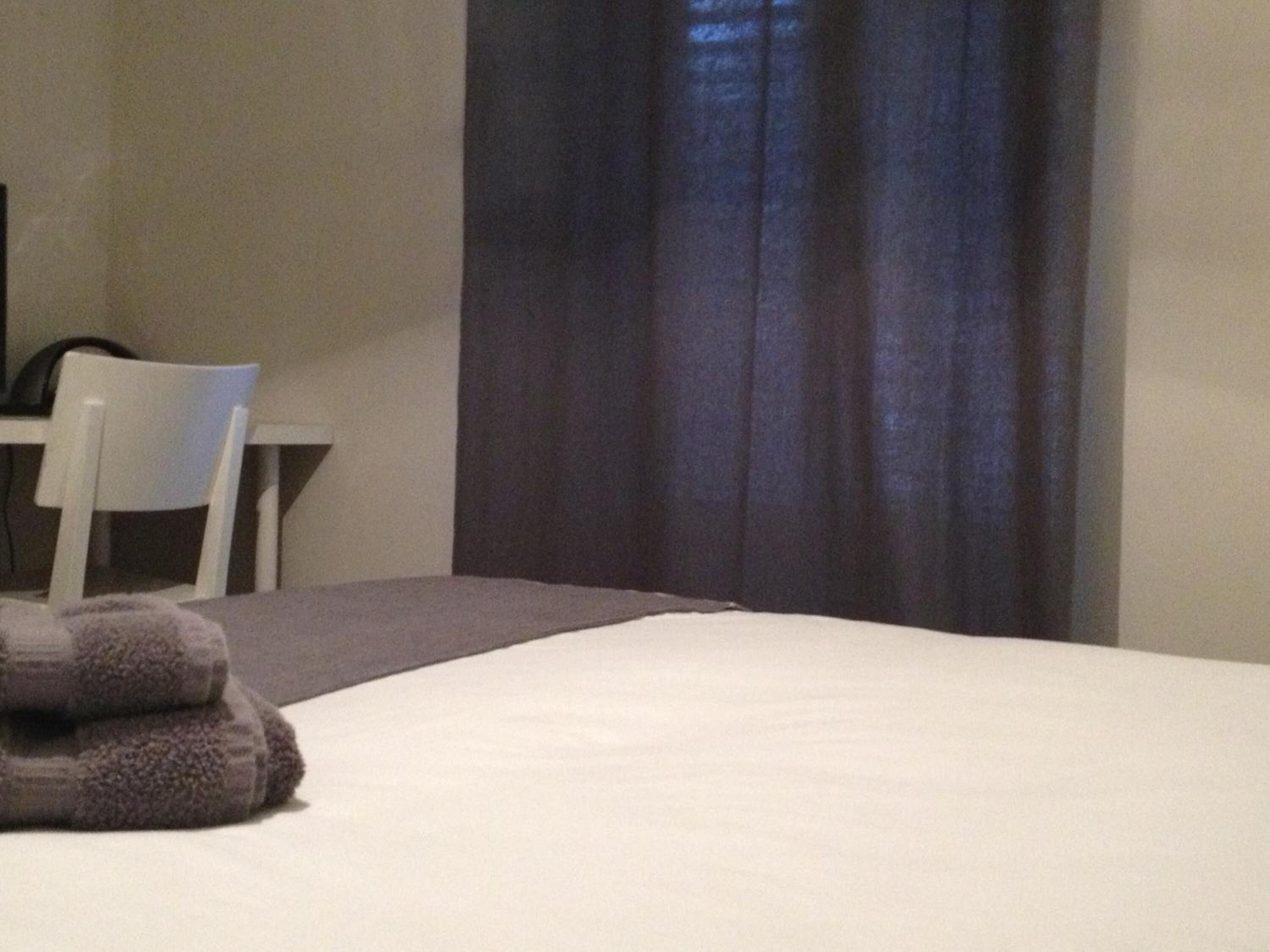 Ein Hotelzimmer mit Bett, Stuhl und Schreibtisch.